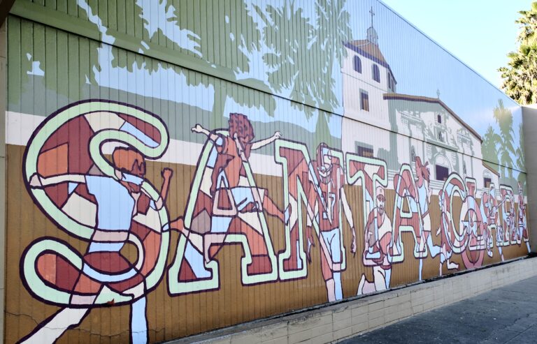 A mural of Santa Clara in big letters with a picture of Mission Santa Clara de Asís