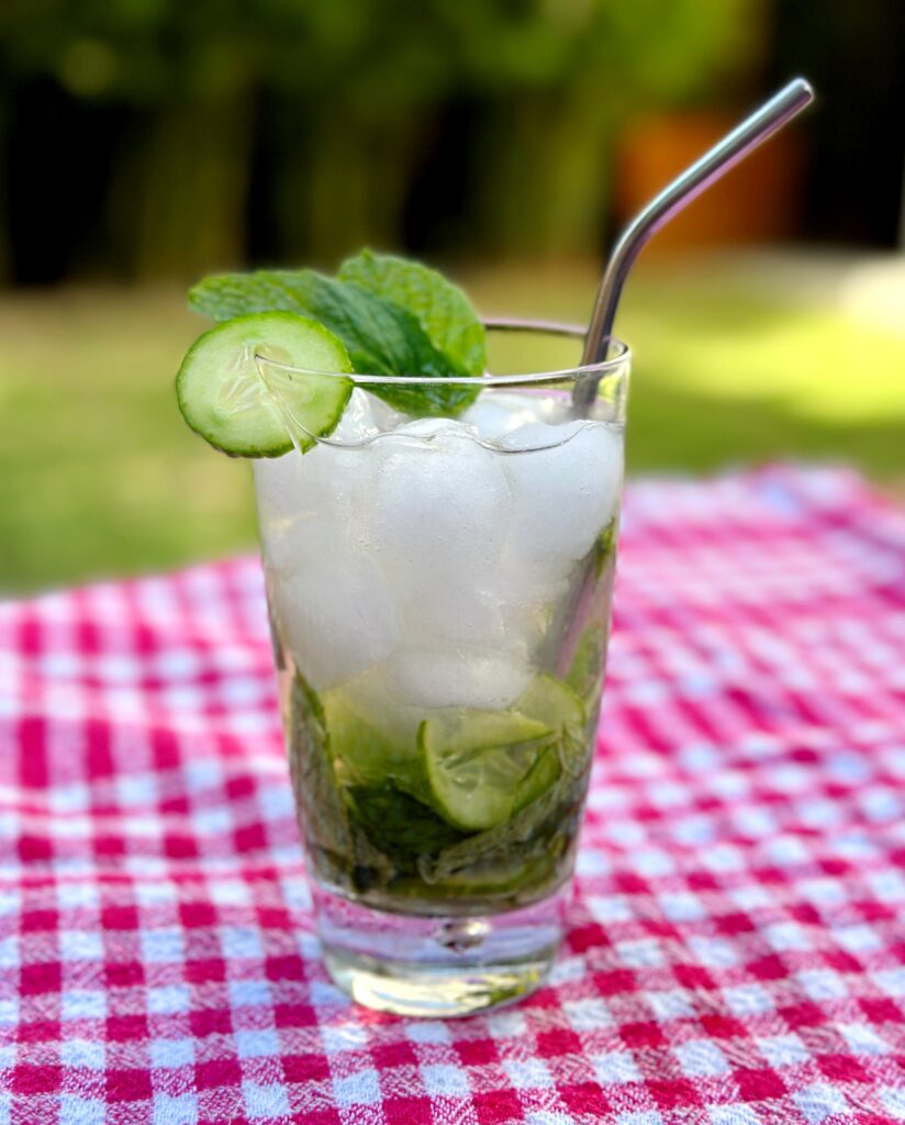 A cool cucumber mint drink for glowing skin served in a glass, garnished with fresh mint leaves and cucumber slices