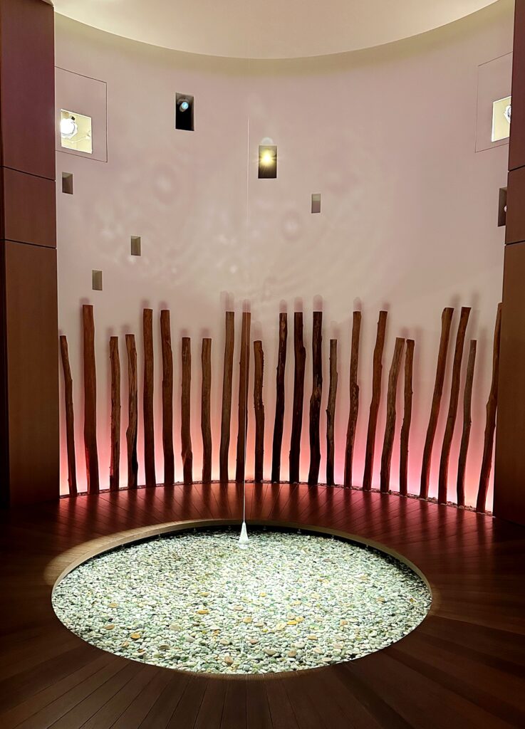 Stone pool at the Laniwai Spa at Aulani Disney Resort, featuring a natural wood wall panel and tranquil atmosphere.