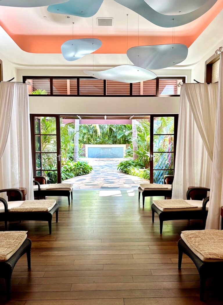 Lounge at Laniwai Spa, Aulani Disney Resort, with lounge chairs, white privacy curtains, and a view of a serene fountain